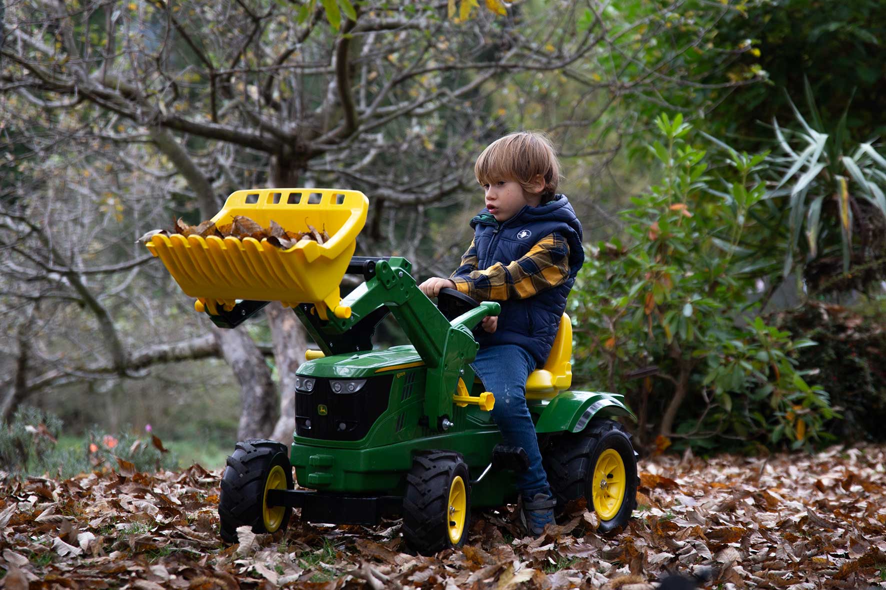 Ein Kind fährt seinen Spielzeug Traktor